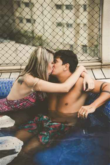 photo of couple kissing while in a pool